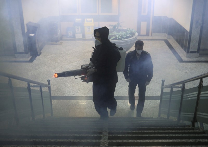 &copy; Reuters. Members of firefighters wear protective face masks, amid fear of coronavirus disease (COVID-19), as they disinfect a municipality building, ahead of the Iranian New Year Nowruz, March 20, in Tehran