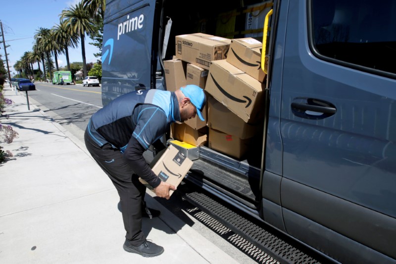 © Reuters. Joseph Alvarado picks up a package while making deliveries for Amazon during the outbreak of the coronavirus disease