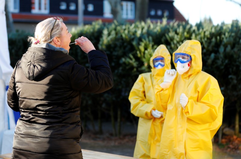 &copy; Reuters. Un equipo de médicos generales con trajes protectores vigila a un paciente en un centro de pruebas de campaña del coronavirus (COVID-19) en el distrito Reinickendorf de Berlín