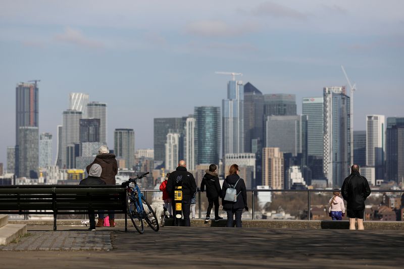 &copy; Reuters. FILE PHOTO: People look out onto the Canary Wharf district as they walk through Greenwich Park in London