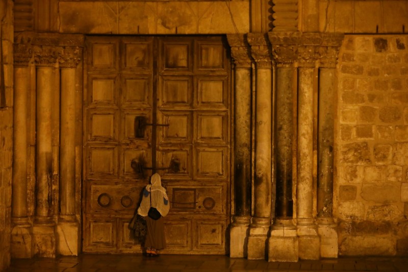 &copy; Reuters. FILE PHOTO: A worshippers stands in front of the closed entrance door of the Church of the Holy Sepulchre in Jerusalem&apos;s Old City