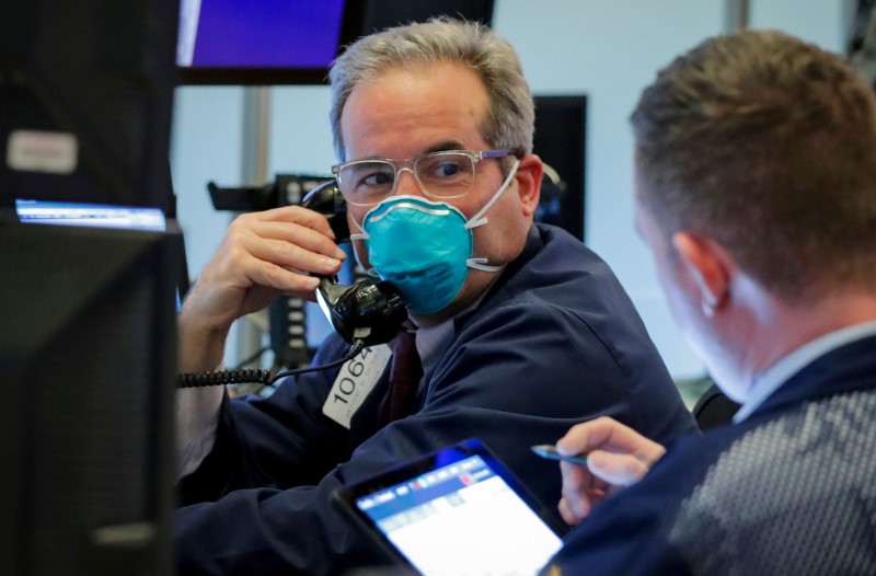 © Reuters. FILE PHOTO: A trader wears a face mask on the floor  of the NYSE in New York