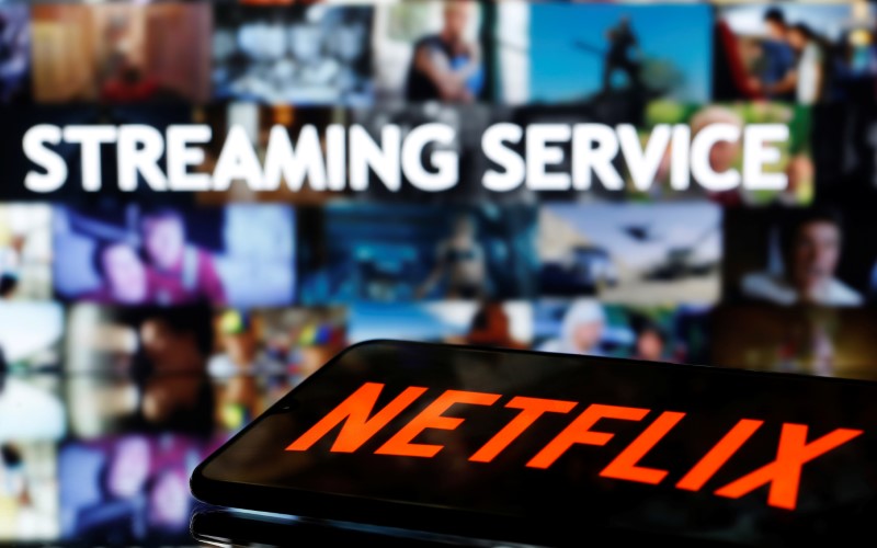 &copy; Reuters. A smartphone with the Netflix logo lies in front of displayed &quot;Streaming service&quot; words in this illustration