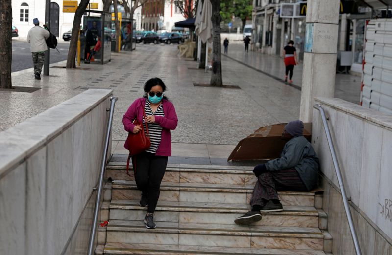 © Reuters. Mulher caminha pelas ruas de Lisboa, em Portugal, com máscara de proteção em meio à pandemia de coronavírus