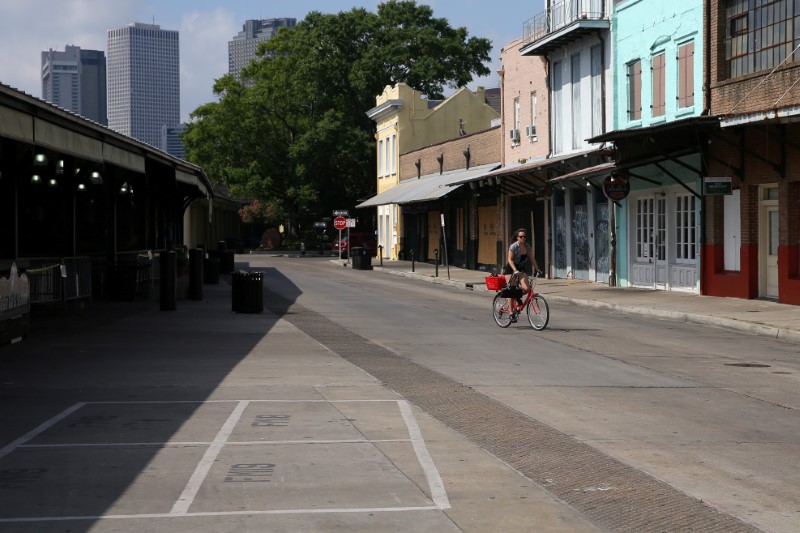 &copy; Reuters. A woman rides her bike through the empty French Market in the French Quarter neighborhood, following the outbreak of the coronavirus disease (COVID-19), in New Orleans