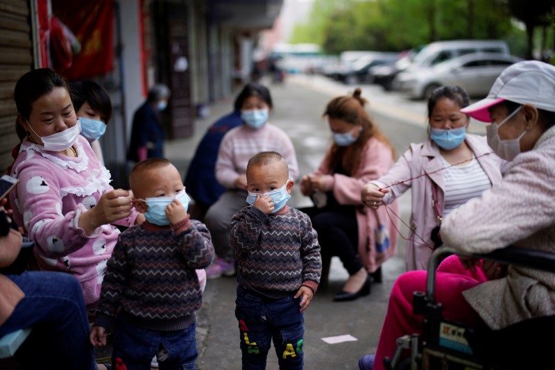 &copy; Reuters. Niños y mujeres con máscaras faciales en Xianning