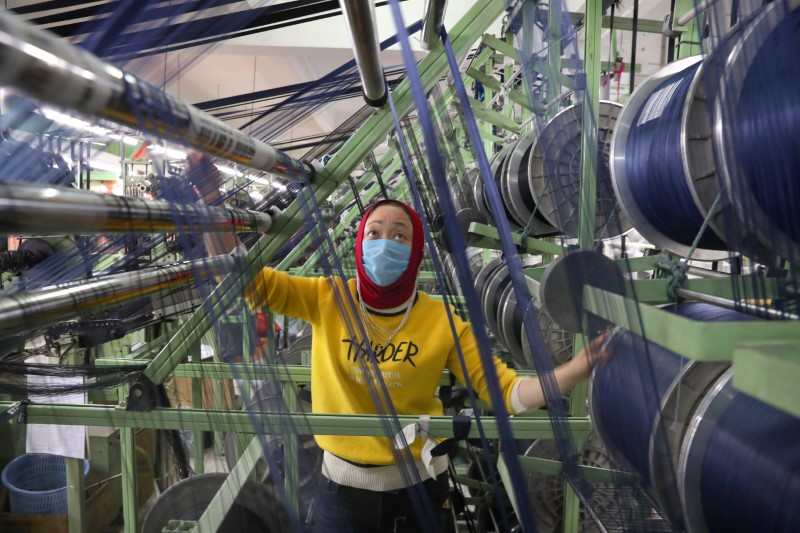 &copy; Reuters. Funcionário de fábrica chinesa trabalha com máscara de proteção