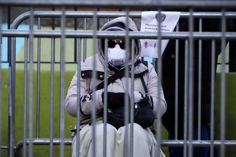 © Reuters. A person waits in line to be tested for coronavirus disease (COVID-19) while wearing protective gear, outside Elmhurst Hospital Center in the Queens borough of New York