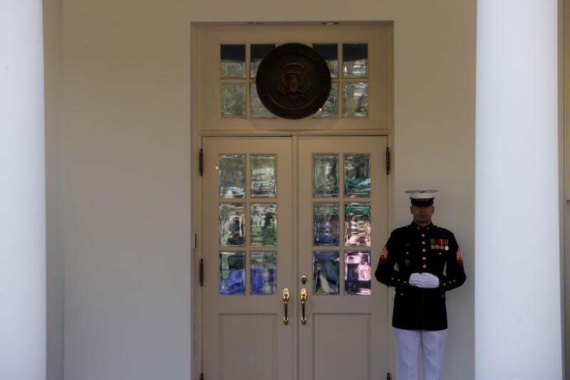 © Reuters. A U.S. Marine stands at the door of the West Wing, where President Donald Trump held meetings throughout the day via phone on the coronavirus response, at the White House in Washington