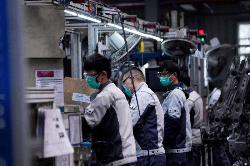 &copy; Reuters. Employees wearing face masks work on a car seat assembly line at Yanfeng Adient factory in Shanghai