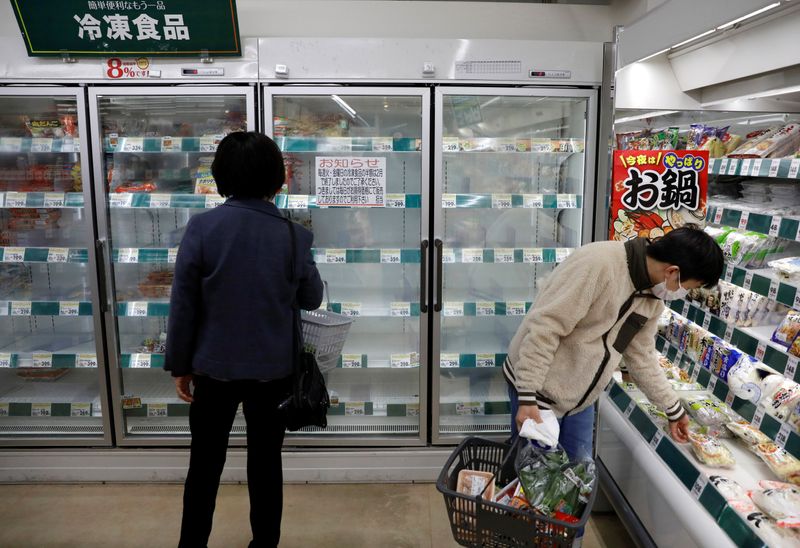 &copy; Reuters. A shopper wearing a protective face mask, following an outbreak of the coronavirus disease, is seen next to an empty shelves of frozen foods at a supermarket in Tokyo, Japan
