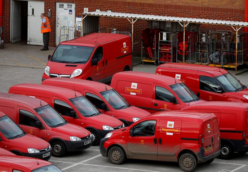 © Reuters. FILE PHOTO: A Royal Mail postal worker stands in the yard of a sorting office in Altrincham,