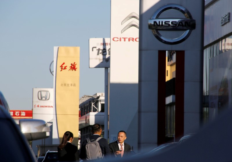 &copy; Reuters. People walk near the showrooms of Chinese and foreign car dealerships in Beijing
