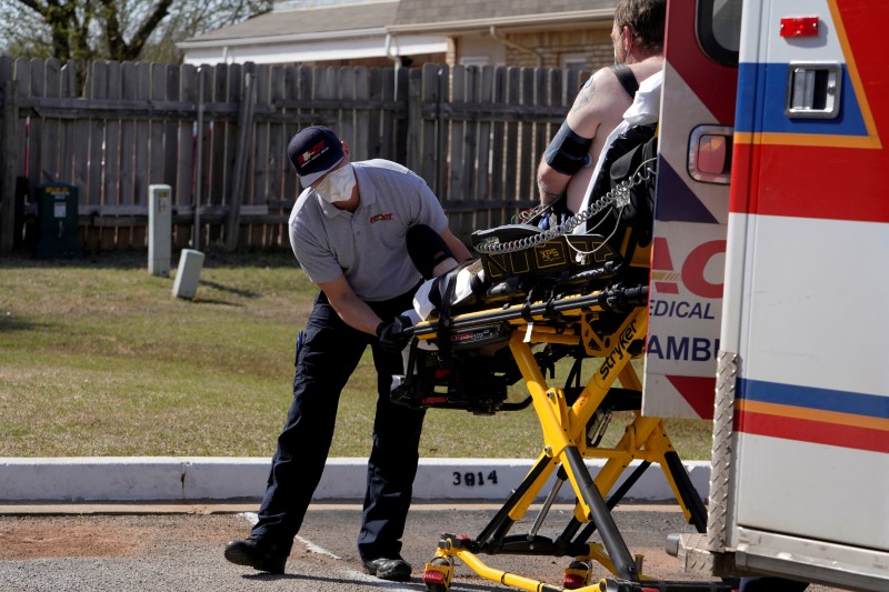 &copy; Reuters. Paramedic Brian Myers loads up a potential coronavirus disease patient for transport in Shawnee