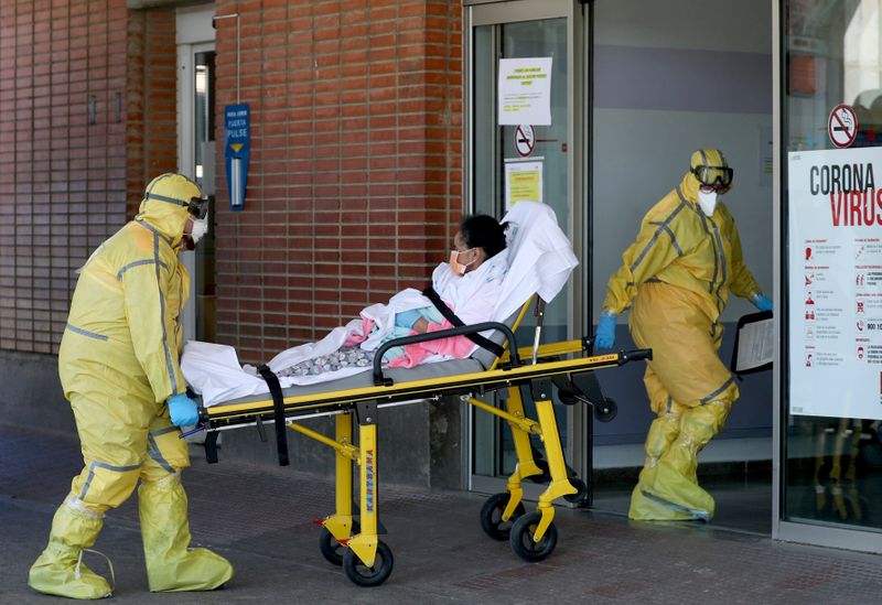 &copy; Reuters. Profissionais de saúde transferem paciente de ambulância para hospital em Leganés, na Espanha