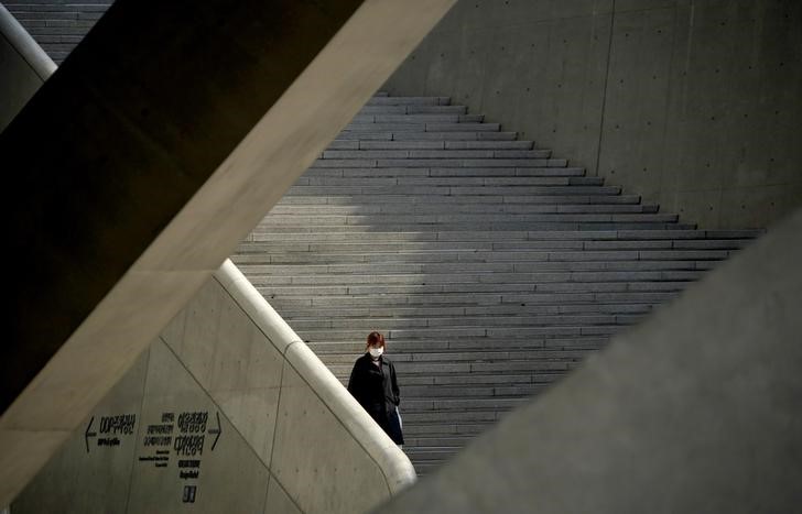 © Reuters. Mulher com máscara de proteção desce escadas em Seul