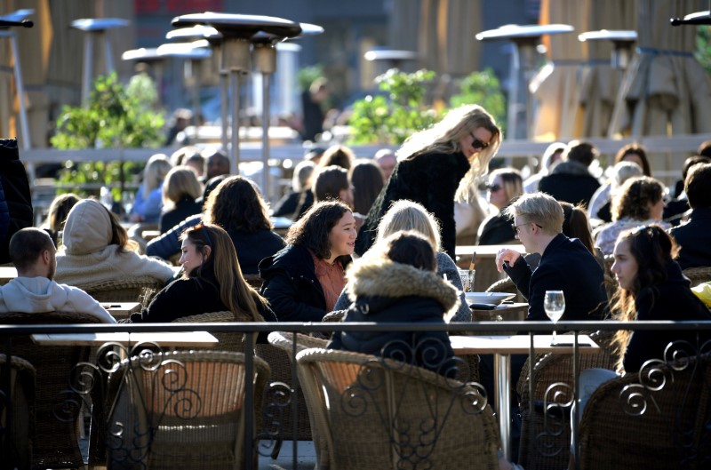 &copy; Reuters. People enjoy the sun at an outdoor restaurant, despite the continuing spread of coronavirus disease (COVID-19), in Stockholm