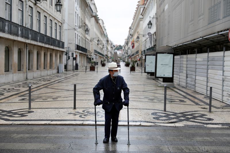&copy; Reuters. Un turista con una máscara protectora camina por la calle Augusta en el centro de Lisboa