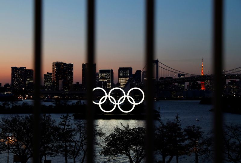 &copy; Reuters. The Olympic rings are pictured at dusk through a steel fence, at the waterfront area of the Odaiba Marine Park, after the postponing of the Olympic Games Tokyo 2020, due to the outbreak of coronavirus disease (COVID 19), in Tokyo