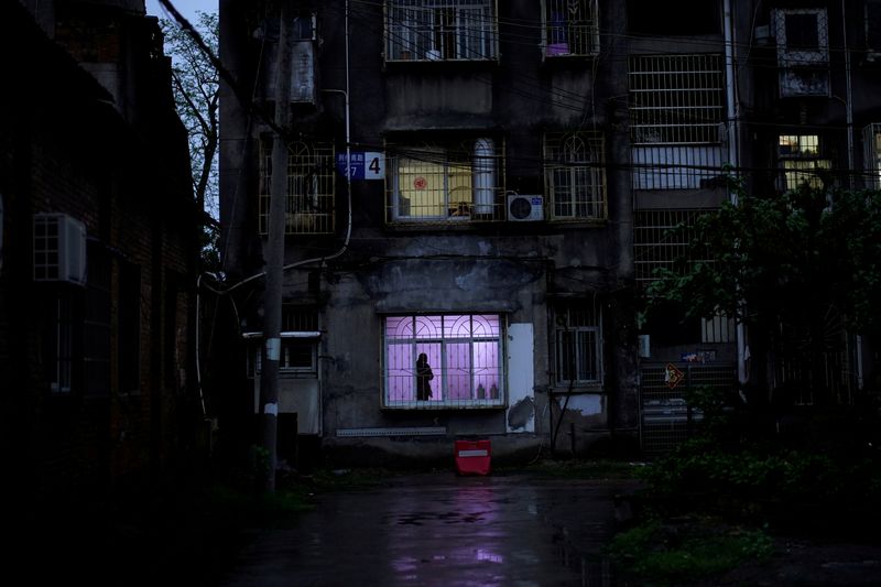 &copy; Reuters. FILE PHOTO: Man stands at a window at a residential community in Jingzhou