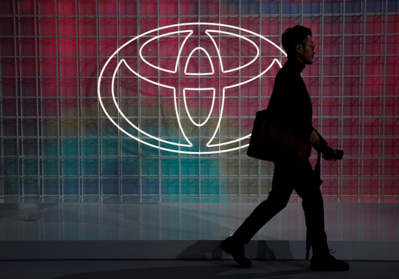 © Reuters. FILE PHOTO: A man walks past a Toyota logo at the Tokyo Motor Show