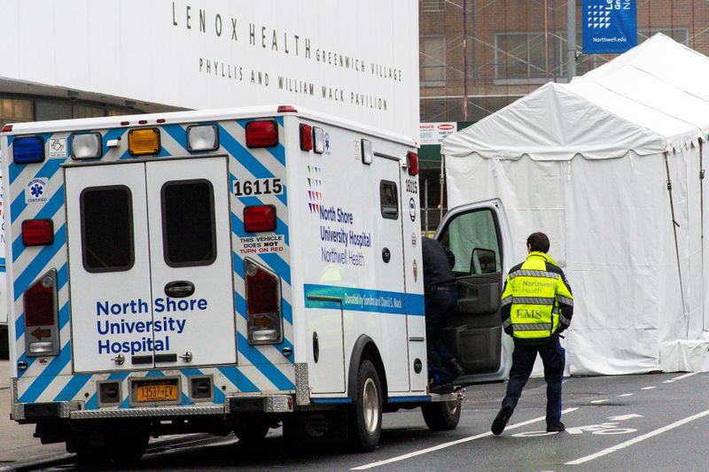 &copy; Reuters. Un paramédico camina junto a una morgue improvisada ubicada fuera del Pabellón Médico de Lenox Health en Nueva York, EEUU, el 29 de marzo de 2020