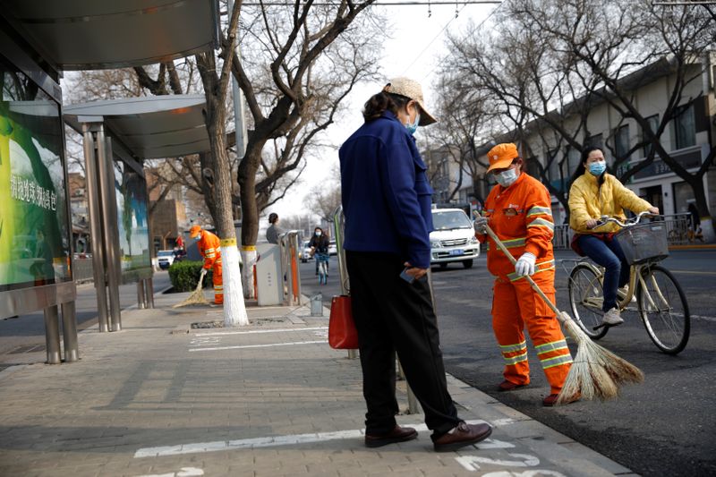 &copy; Reuters. Люди в защитных масках на улице в Пекине