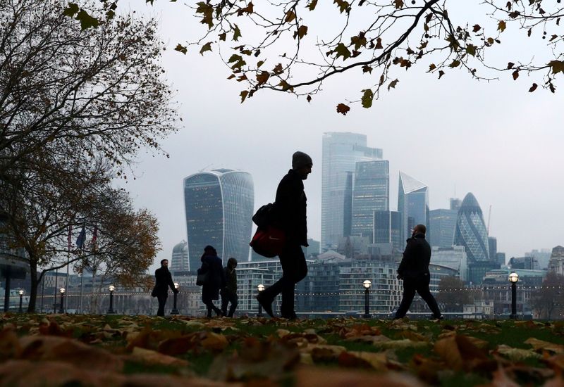 &copy; Reuters. FILE PHOTO: People walk through autumnal leaves in front of the financial district in London