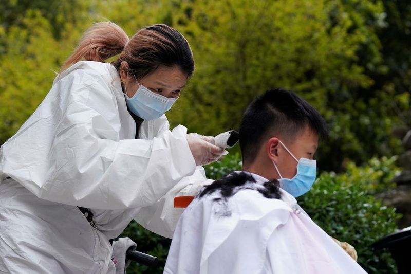 &copy; Reuters. Barber Xiong Juan cuts a customer&apos;s hair at a residential compound in Wuhan