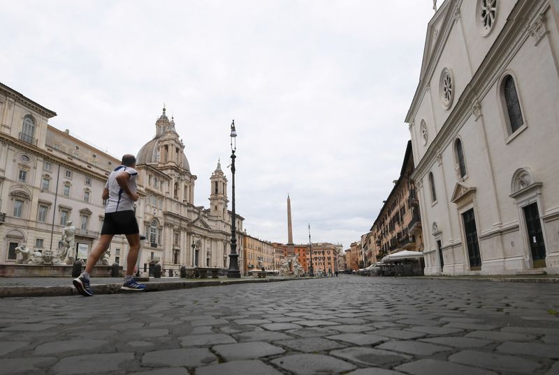 &copy; Reuters. FOTO DE ARCHIVO: Un hombre corre en una plaza vacía de Navona mientras Italia endurece las medidas para tratar de contener la propagación de la enfermedad coronavirus (COVID-19), en Roma, Italia