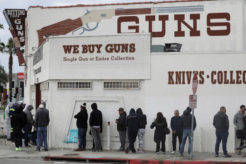 &copy; Reuters. FILE PHOTO: People wait in line outside to buy supplies at the Martin B. Retting, Inc. gun store amid fears of the global growth of coronavirus cases, in Culver City