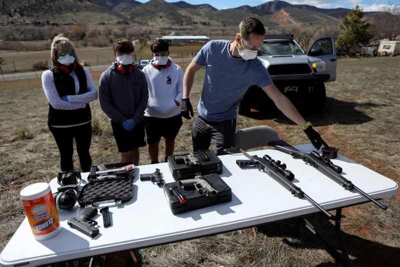 © Reuters. Firearms instructor Joseph Wilkey prepares rifles and hand guns sitting next to a container of disinfecting wipes during a firearms safety class conducted by Level Up Firearms outside Loveland