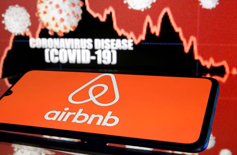 © Reuters. FILE PHOTO: Airbnb logo is seen in front of diplayed coronavirus disease (COVID-19)