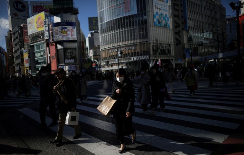 &copy; Reuters. FILE PHOTO: Woman, wearing protective face mask, following an outbreak of the coronavirus, is pictured at the scramble crossing in Shibuya shopping district in Tokyo