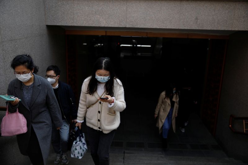 &copy; Reuters. People wearing face masks exit a subway station following an outbreak of the coronavirus disease (COVID-19), in Beijing