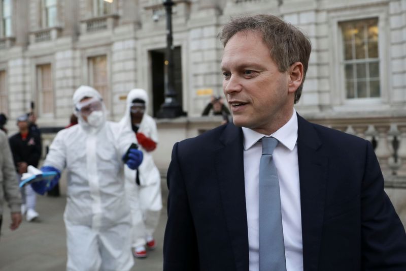 &copy; Reuters. Britain&apos;s Secretary of State for Transport Grant Shapps is seen in front of men in protective suits pretending to clean the cabinet as part of a stunt for social media, as the number of coronavirus cases (COVID-19) grows around the world, in London