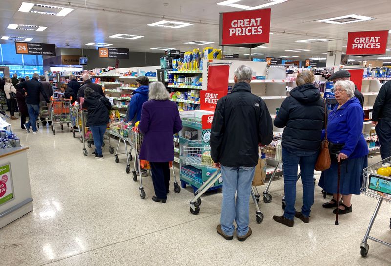 &copy; Reuters. FILE PHOTO: People queue inside a Sainsburys supermarket in Watford