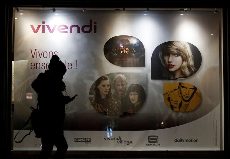 &copy; Reuters. A woman walks pass by a sign of Vivendi at the main entrance of the entertainment-to-telecoms conglomerate headquarters in Paris