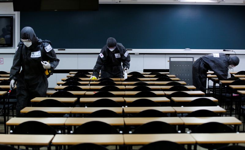&copy; Reuters. FOTO DE ARCHIVO: Soldados surcoreanos desinfectan pupitres en un aula de una escuela para exámenes acceso a la Administración pública en Daegu