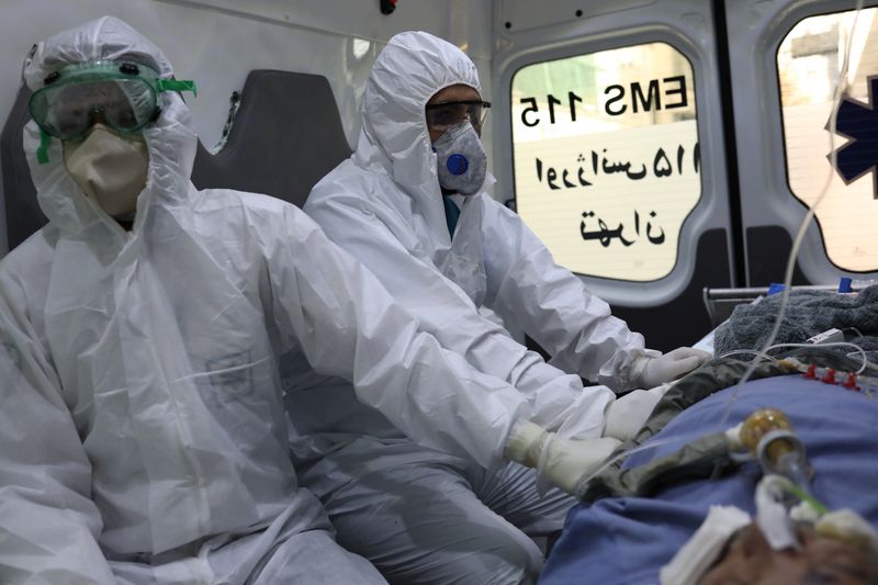 &copy; Reuters. Emergency medical staff wearing protective suits, sit in an ambulance while transferring a patient with coronavirus disease (COVID-19) to Masih Daneshvari Hospital, in Tehran