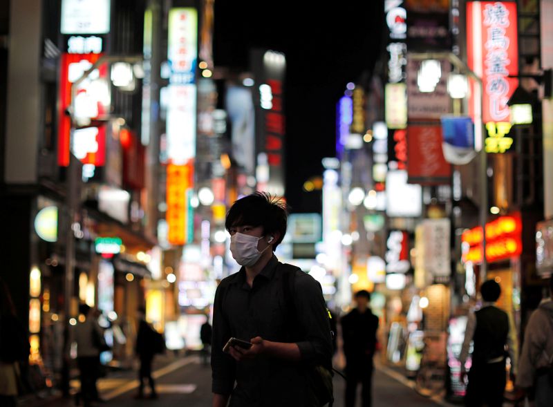 &copy; Reuters. Homem com máscara de proteção contra coronavírus caminha pelas ruas de Tóquio