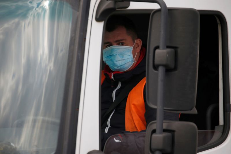 © Reuters. FILE PHOTO: A truck driver wearing a protective face mask arrives at the Amazon logistics center in Lauwin-Planque