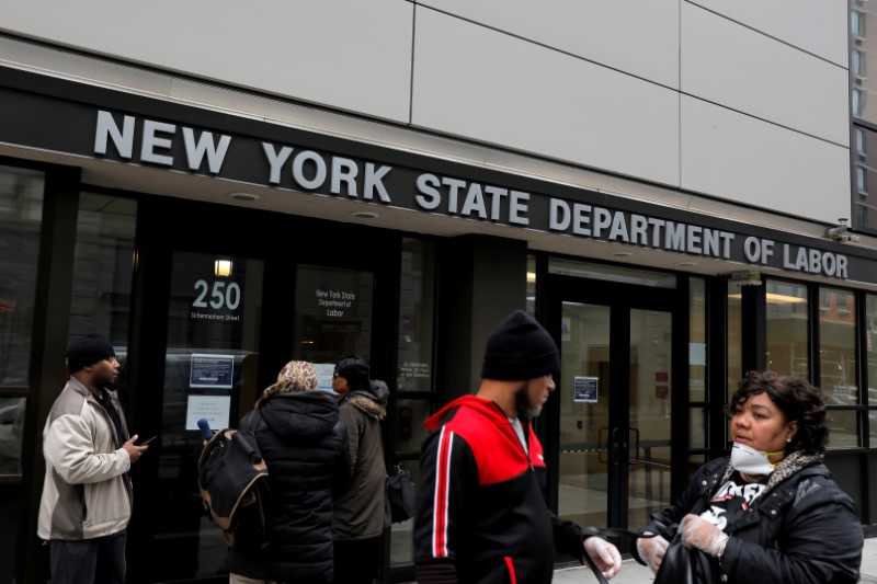 © Reuters. FILE PHOTO: People gather at the entrance for the New York State Department of Labor offices, which closed to the public due to the coronavirus disease (COVID-19) outbreak in the Brooklyn borough of New York City