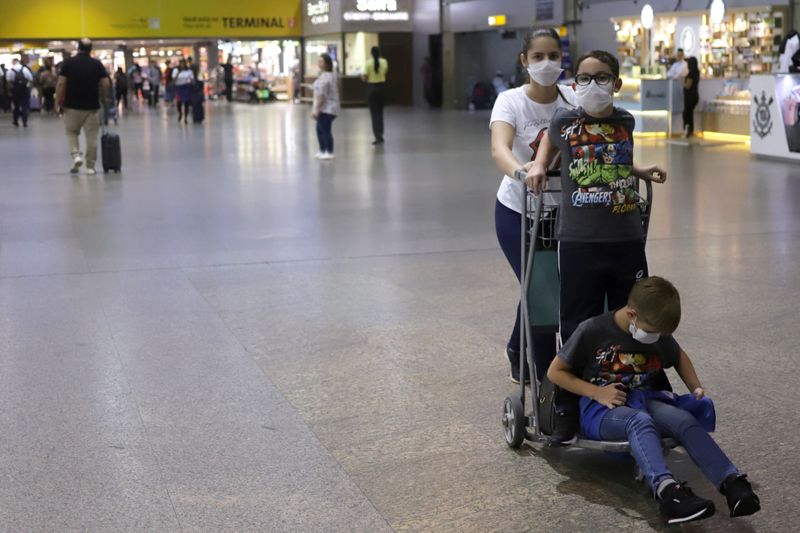 &copy; Reuters. Pessoas usam máscaras de proteção no aeroporto de Guarulhos