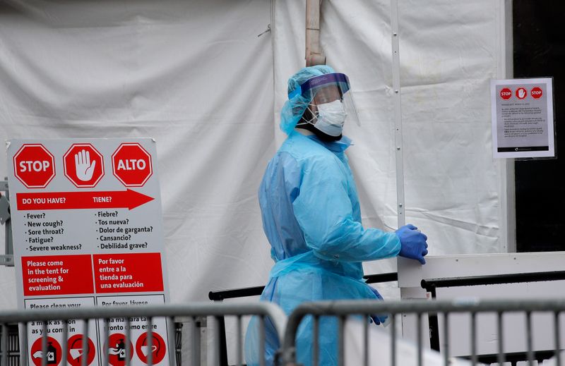 &copy; Reuters. Profissional de saúde com trajes de proteção entra em centro hospitalar em Nova York durante pandemia de Covid-19