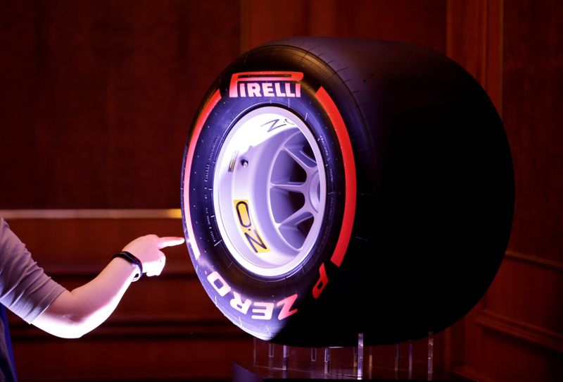 © Reuters. FILE PHOTO: A woman touches a Pirelli tyre displayed for a news conference by ChemChina and Pirelli in Beijing