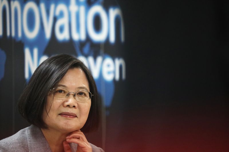 &copy; Reuters. Taiwanese president Tsai Ing-Wen listens to a presentation at a non woven filter fabric factory, where the fabric is used to make surgical face masks, in Taoyuan, Taiwan,