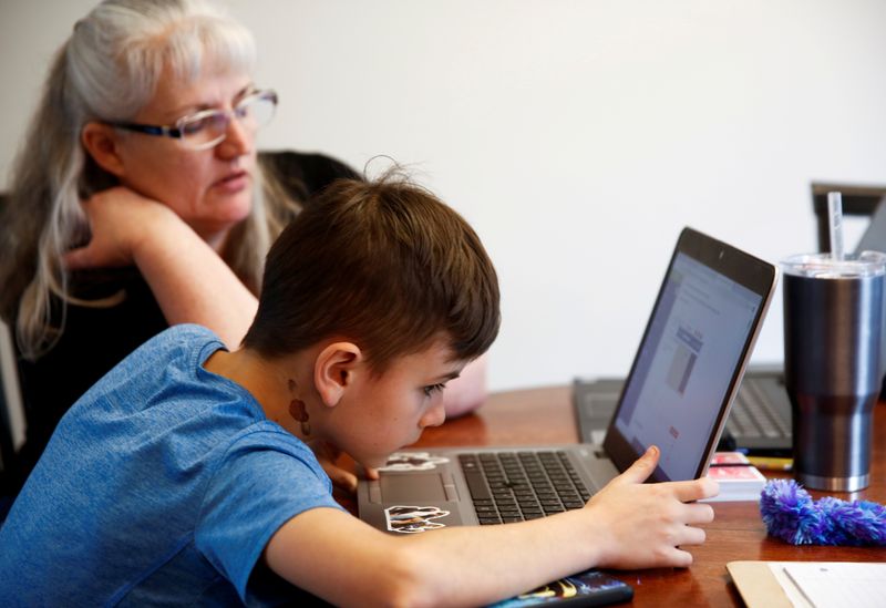 &copy; Reuters. FILE PHOTO: 4th grader at Cottage Lake Elementary, tries to figure out assignment instructions without working speakers on his laptop as he and his grandmother navigate the online learning system the Northshore School District will use due to coronavirus 