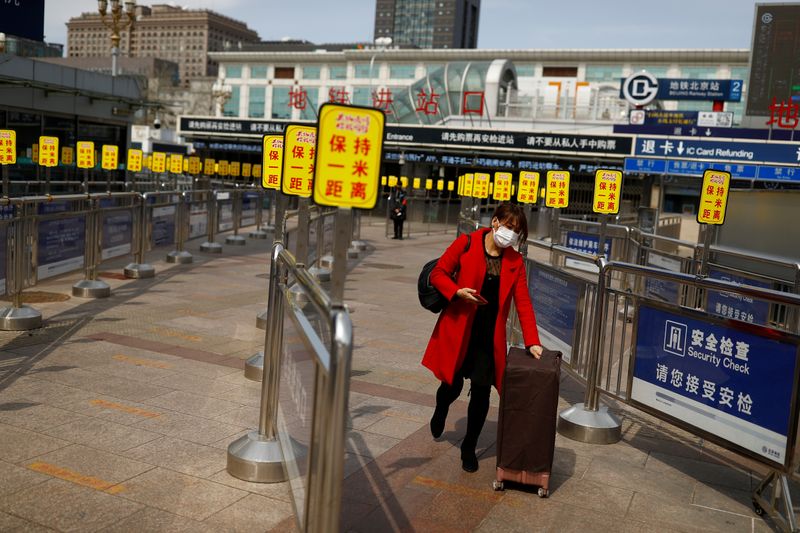 &copy; Reuters. Женщина в защитной маске выходит со станции метро в Пекине