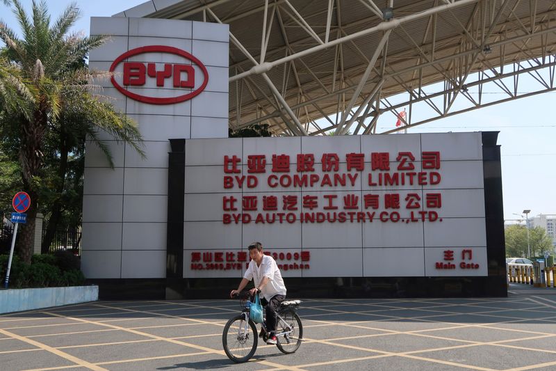 &copy; Reuters. FILE PHOTO: Man cycles past an entrance to the headquarters of Chinese electric car maker BYD in Shenzhen